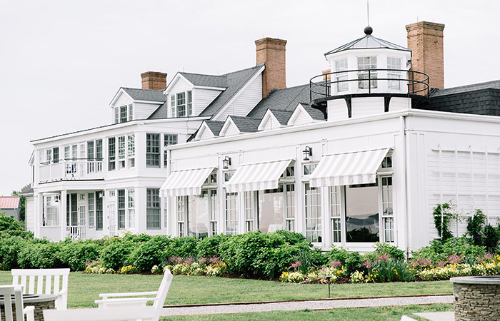 a white building with a lawn and a bench
