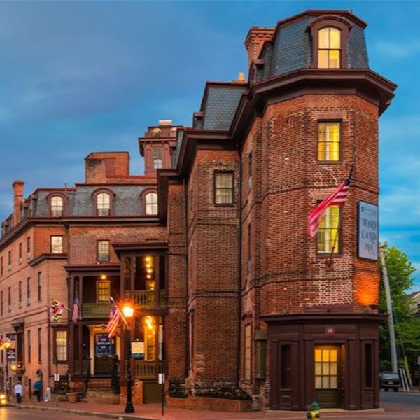 a brick building with flags on the corner of a street