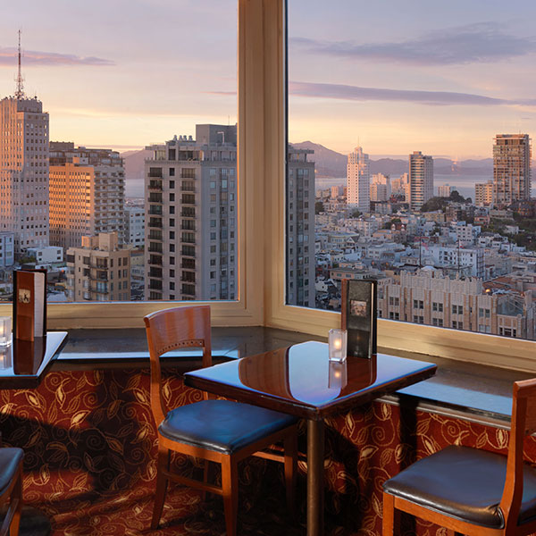 a table and chairs in a room with a view of a city