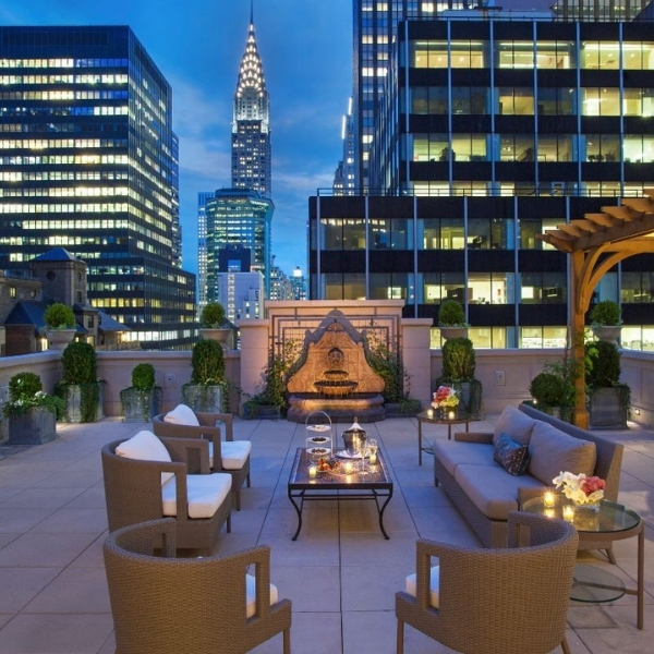 a rooftop patio with a fountain and chairs