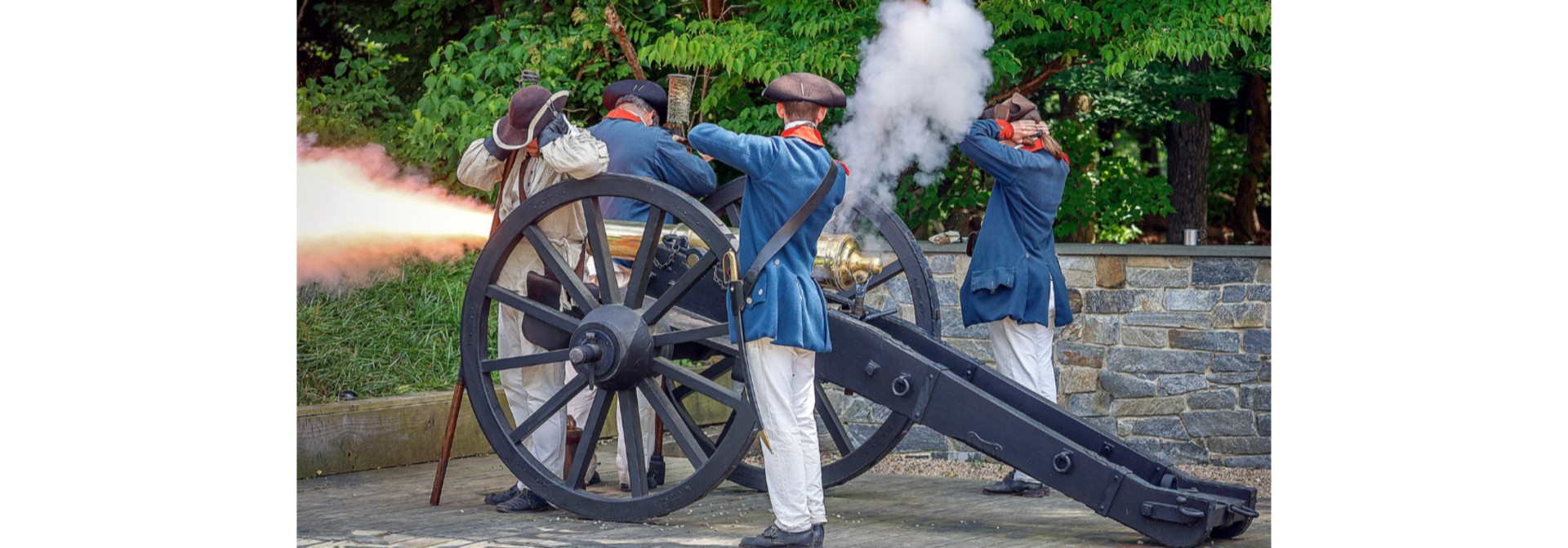 a group of people in uniform firing a cannon