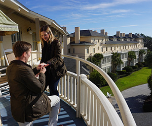 a man proposing to a woman on a balcony