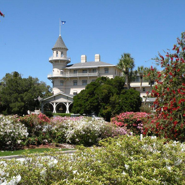 a large white building with a tower and a garden