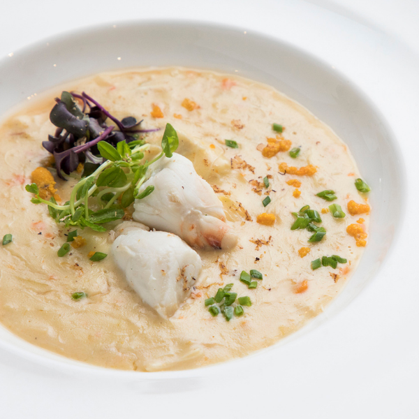 a bowl of soup with fish and vegetables