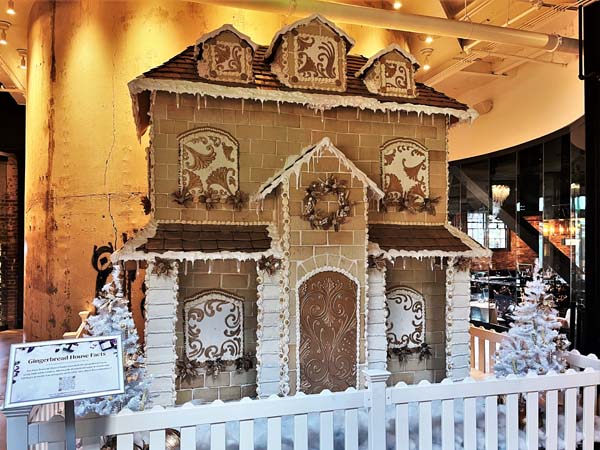 a gingerbread house with a white fence