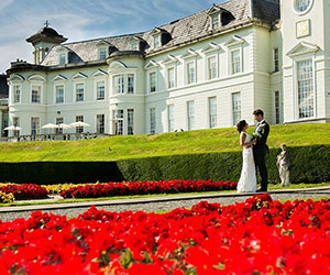 a man and woman in front of a large white building
