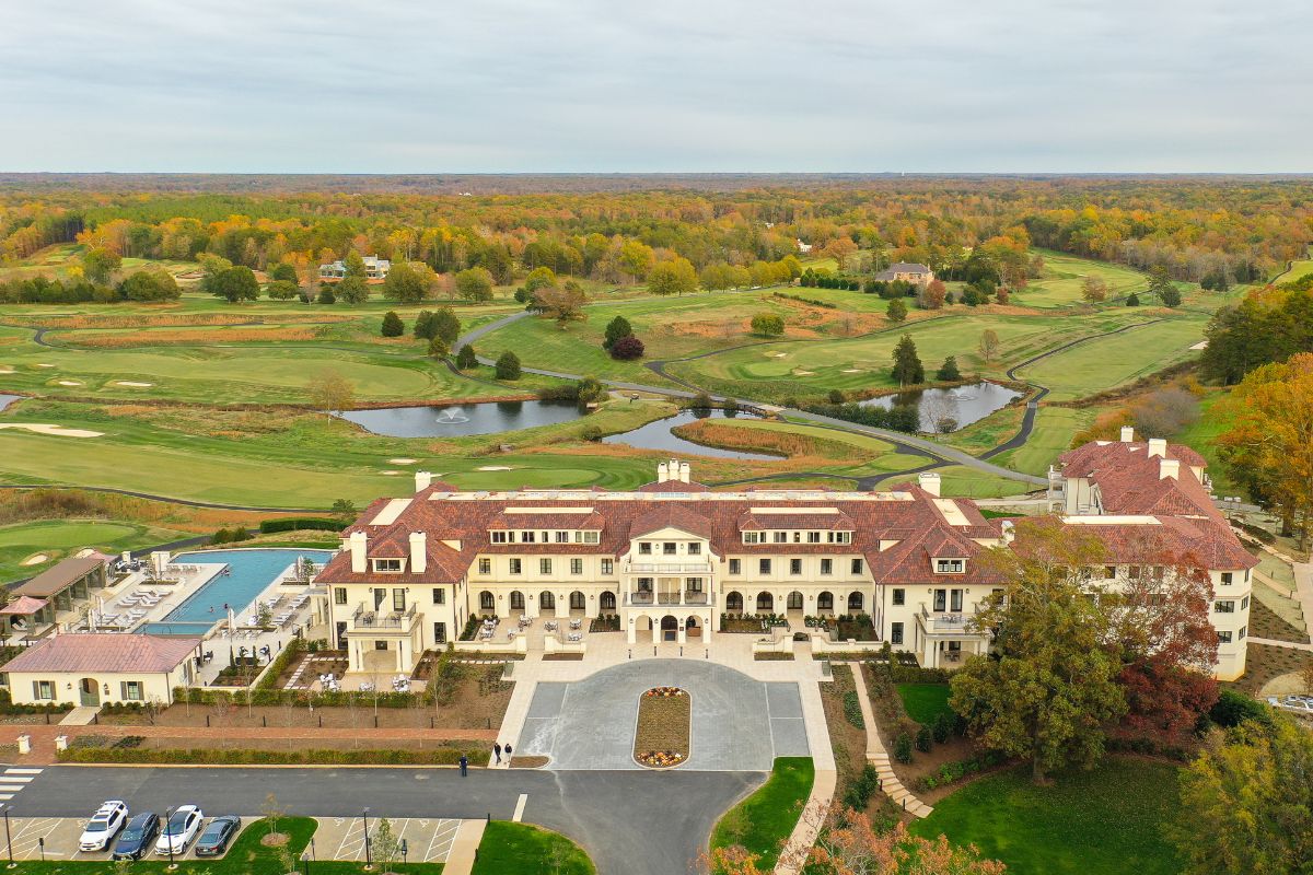 a large building with a pool and trees in the background