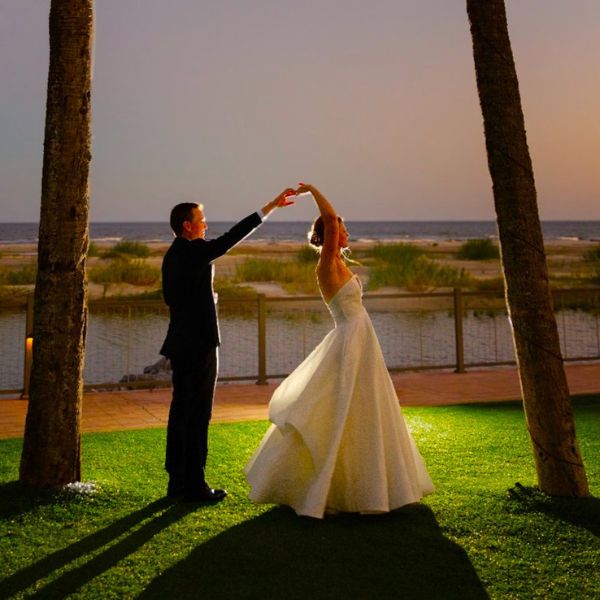 a man and woman dancing on grass