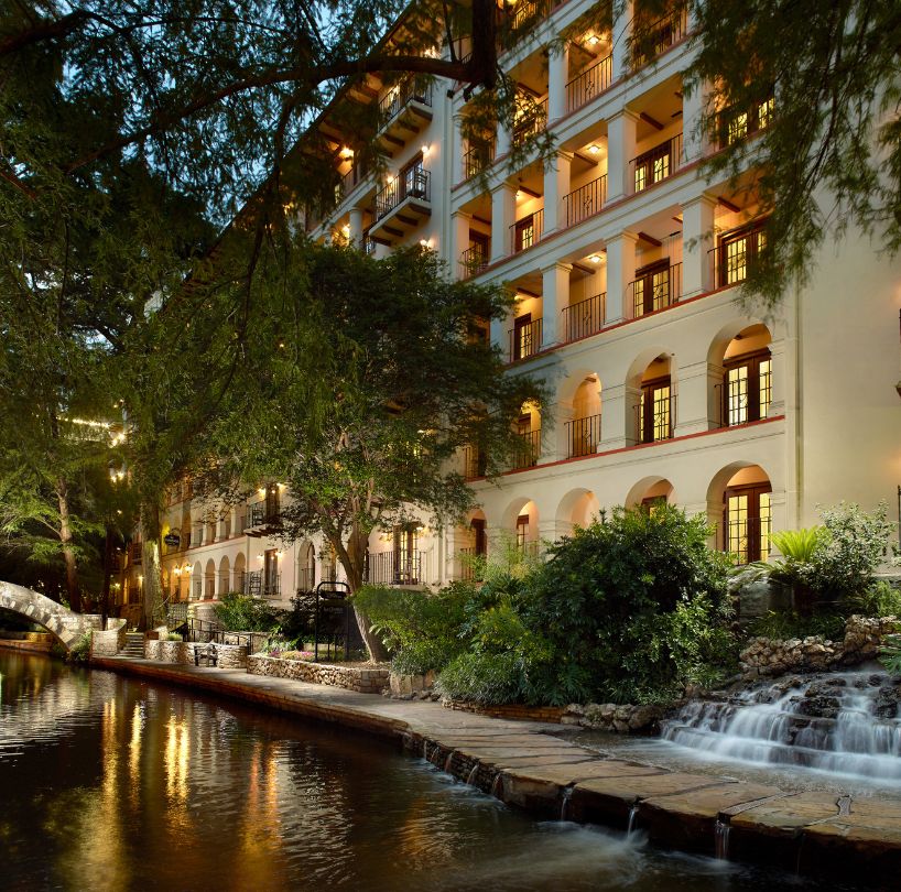 a building with a waterfall and trees