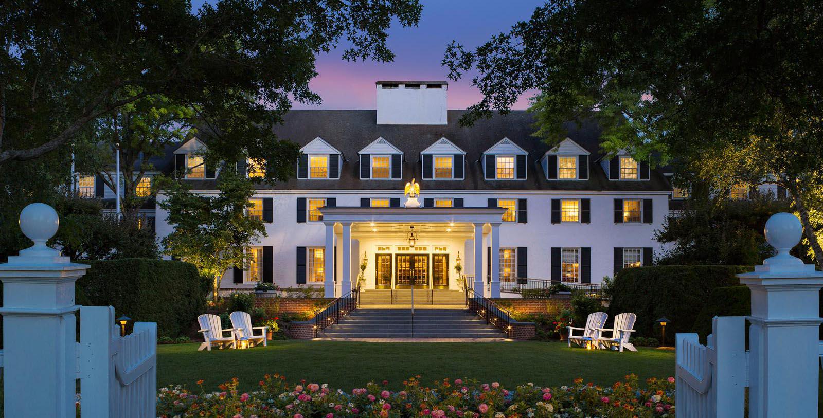 a large white building with a lawn and lawn chairs 62