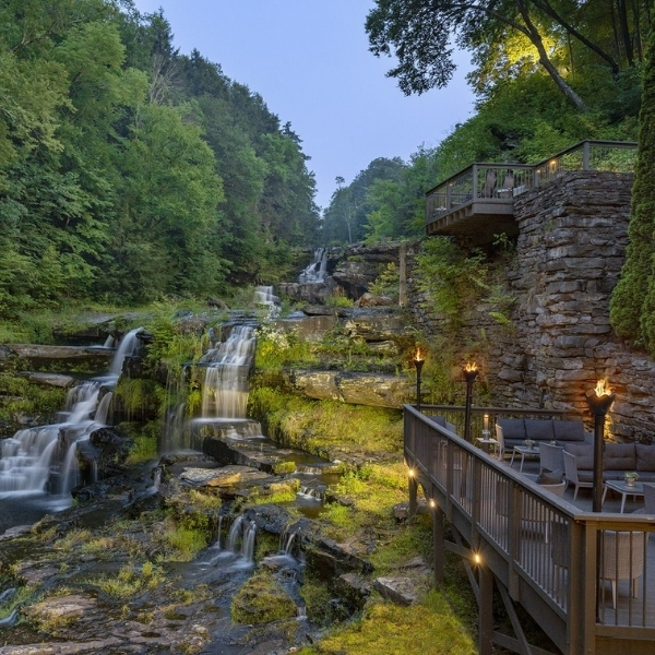 a waterfall with a deck and chairs