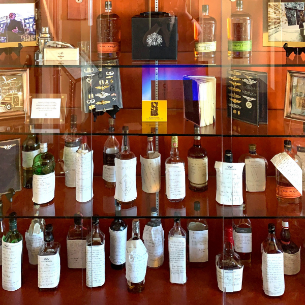 a glass case with bottles of alcohol
