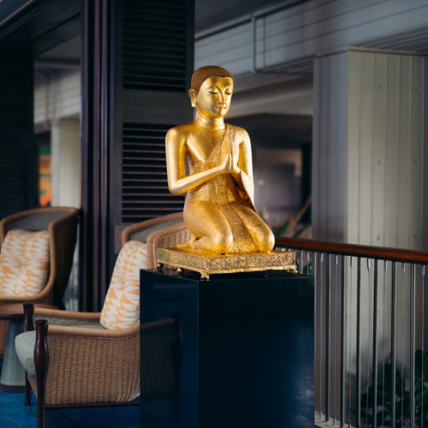 a gold statue of a person sitting on a pedestal