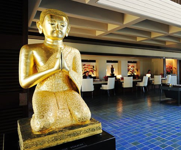 a golden statue of a man sitting on a pedestal
