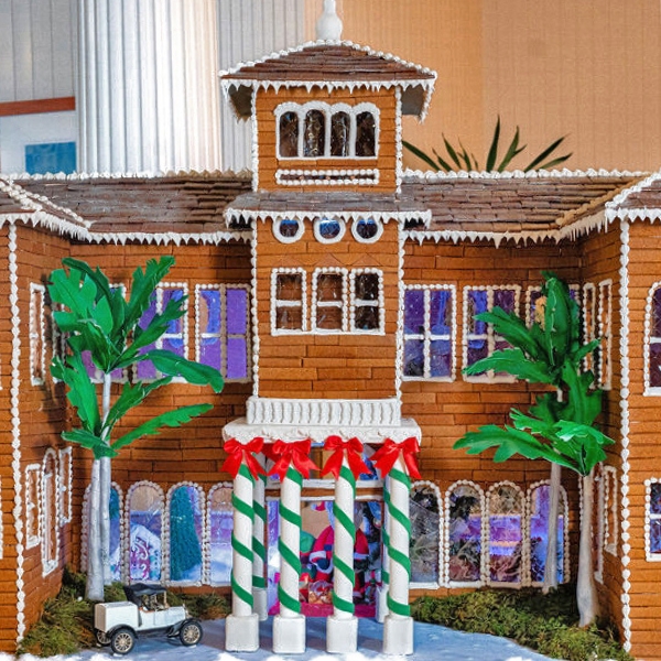 a gingerbread house with palm trees and a golf cart
