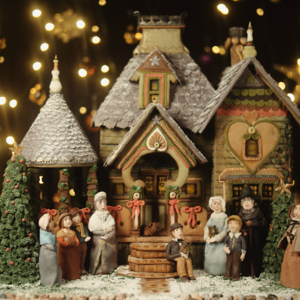 a gingerbread house with people and trees