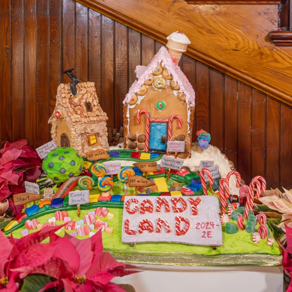 a gingerbread house with candy canes and a sign