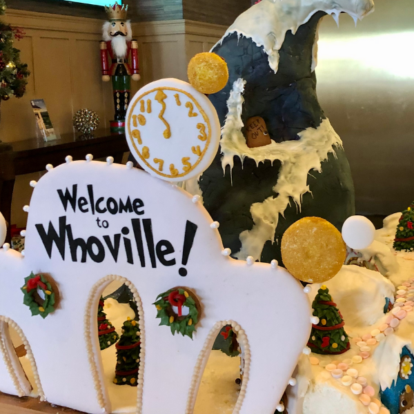 a gingerbread house with a clock and a giant bear