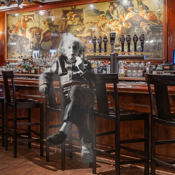 a man sitting in a chair at a bar