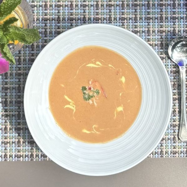 a bowl of soup with a spoon and a glass of lemon