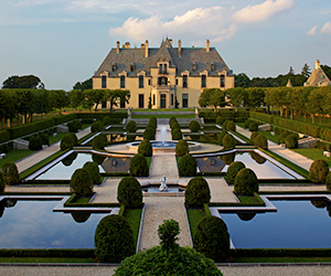a large formal garden with a large building in the background with Vaux-le-Vicomte in the background