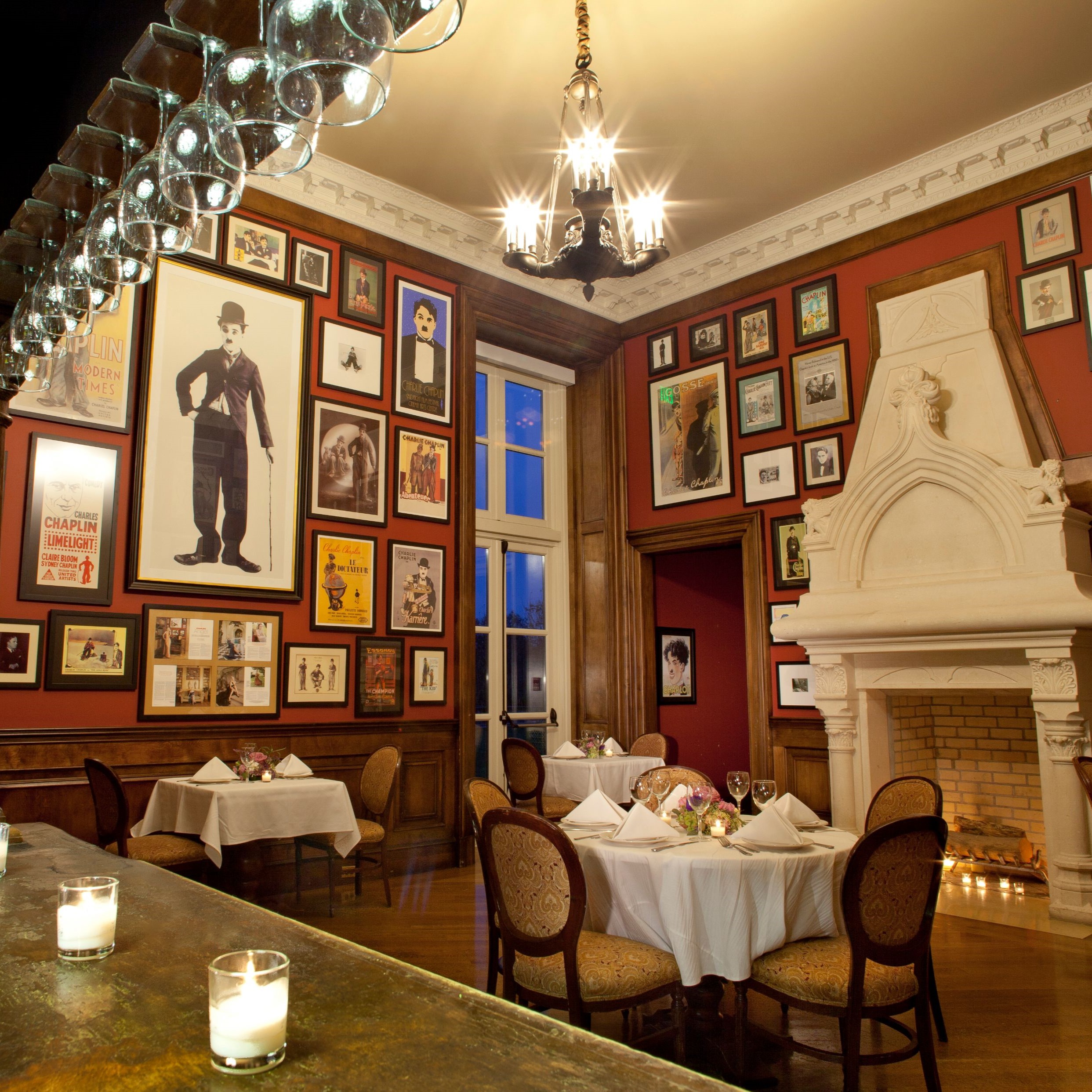 a room with a fireplace and tables and chairs