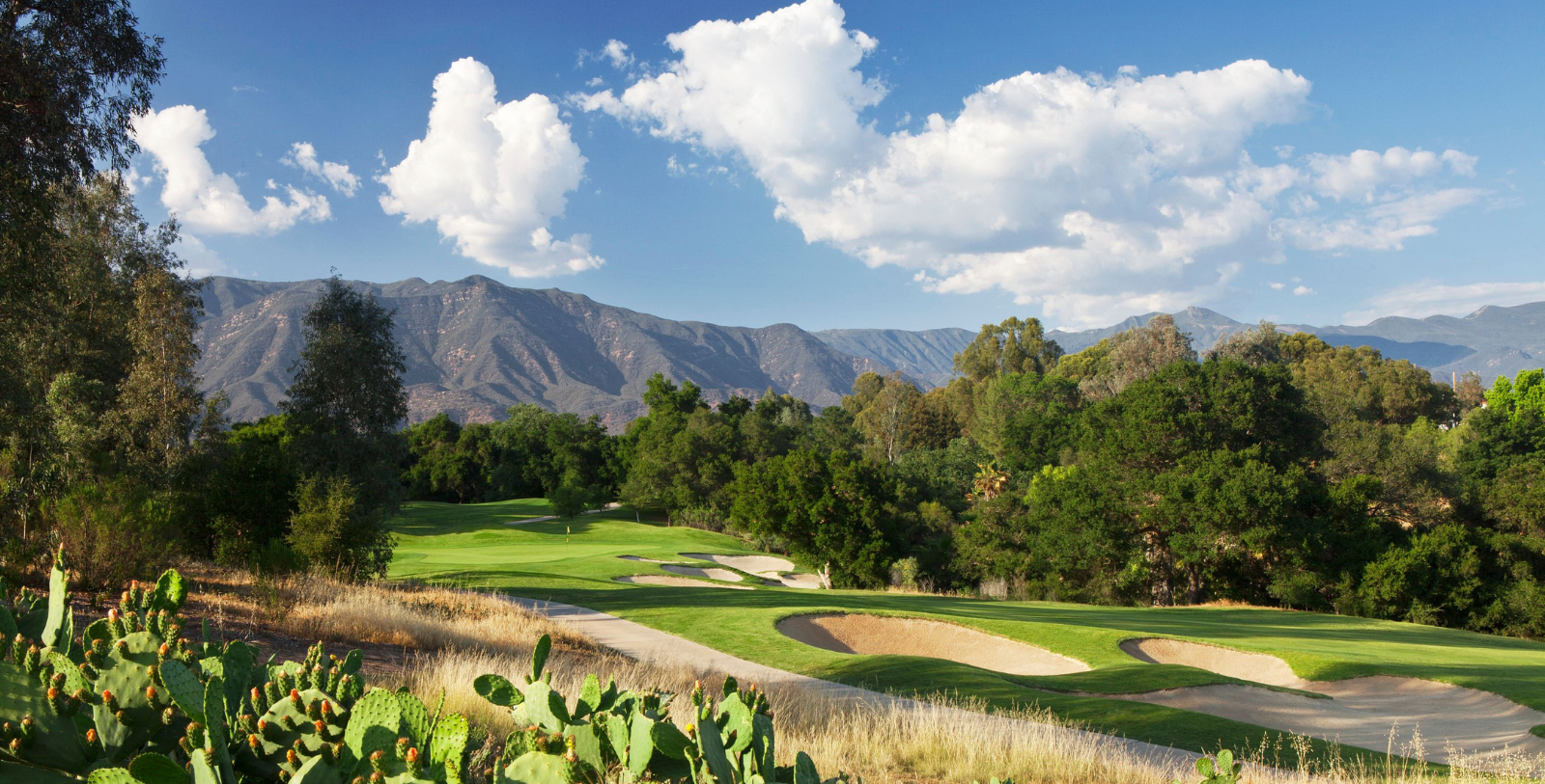 a golf course with a mountain in the background
