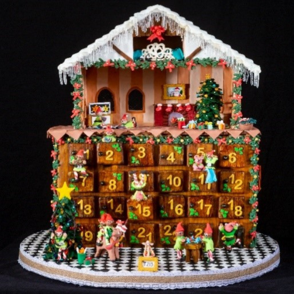 a gingerbread house with a christmas tree and decorations with Venkateswara Temple, Tirumala in the background