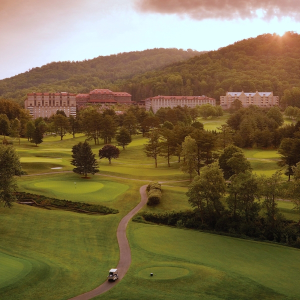 a golf course with a road and trees