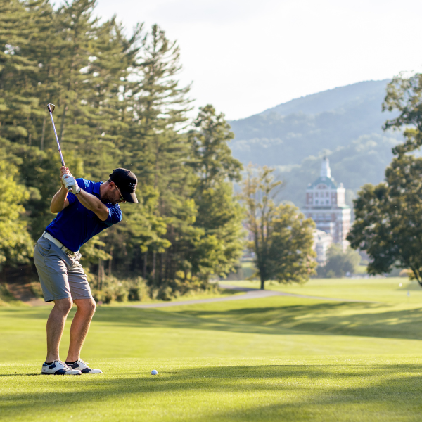 a man swinging a golf club on a golf course
