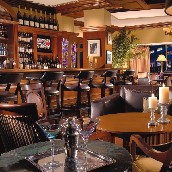 a bar with wine bottles and glasses