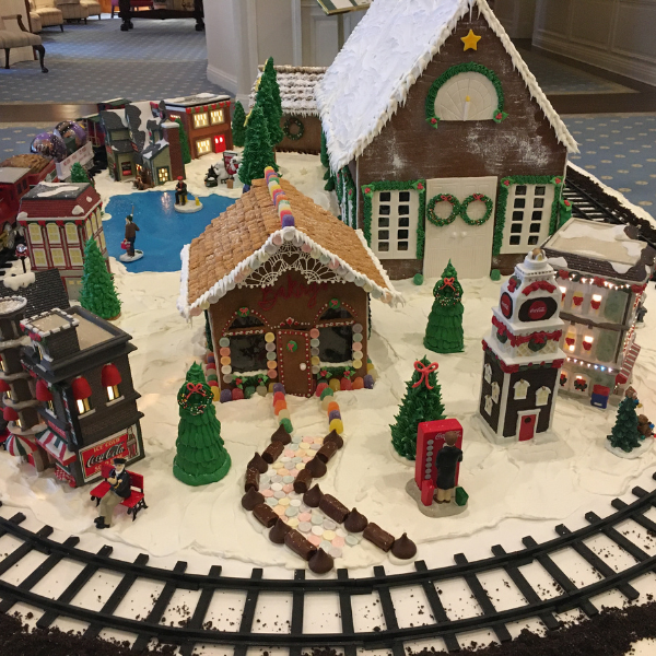 a gingerbread house with train tracks and trees