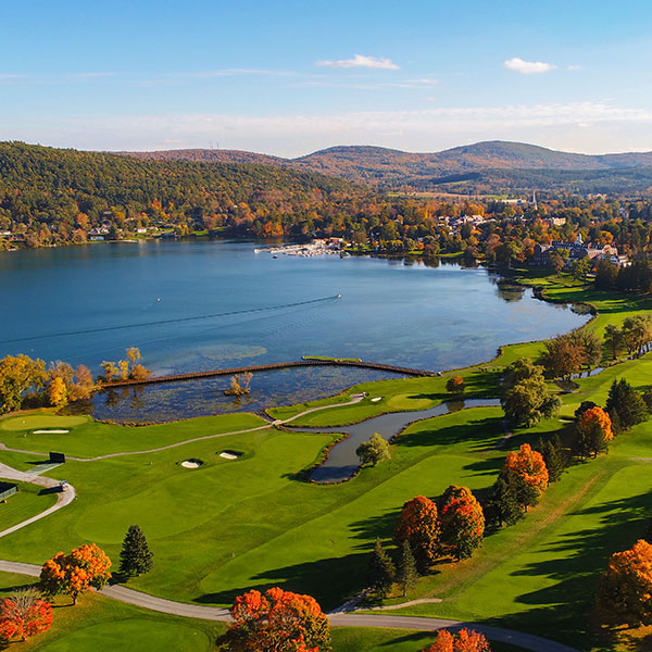 a golf course with a body of water and trees