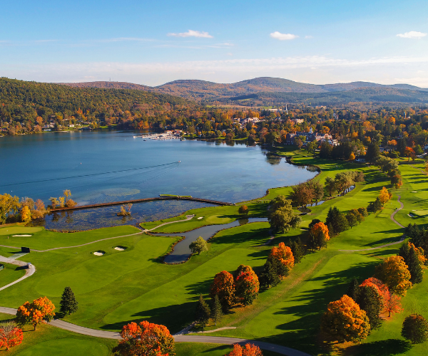 a golf course with a body of water and trees