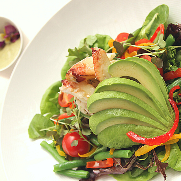a plate of salad with avocado and vegetables
