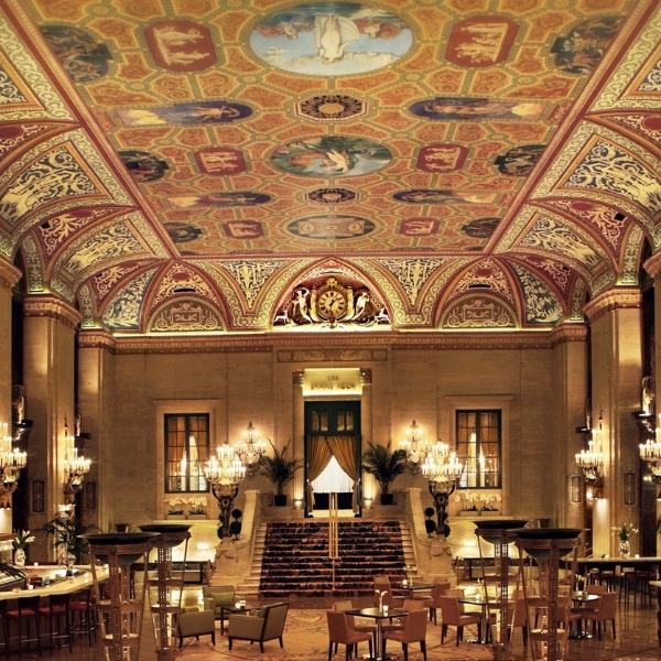 a large ornate room with chandeliers and tables with The Palmer House Hilton in the background