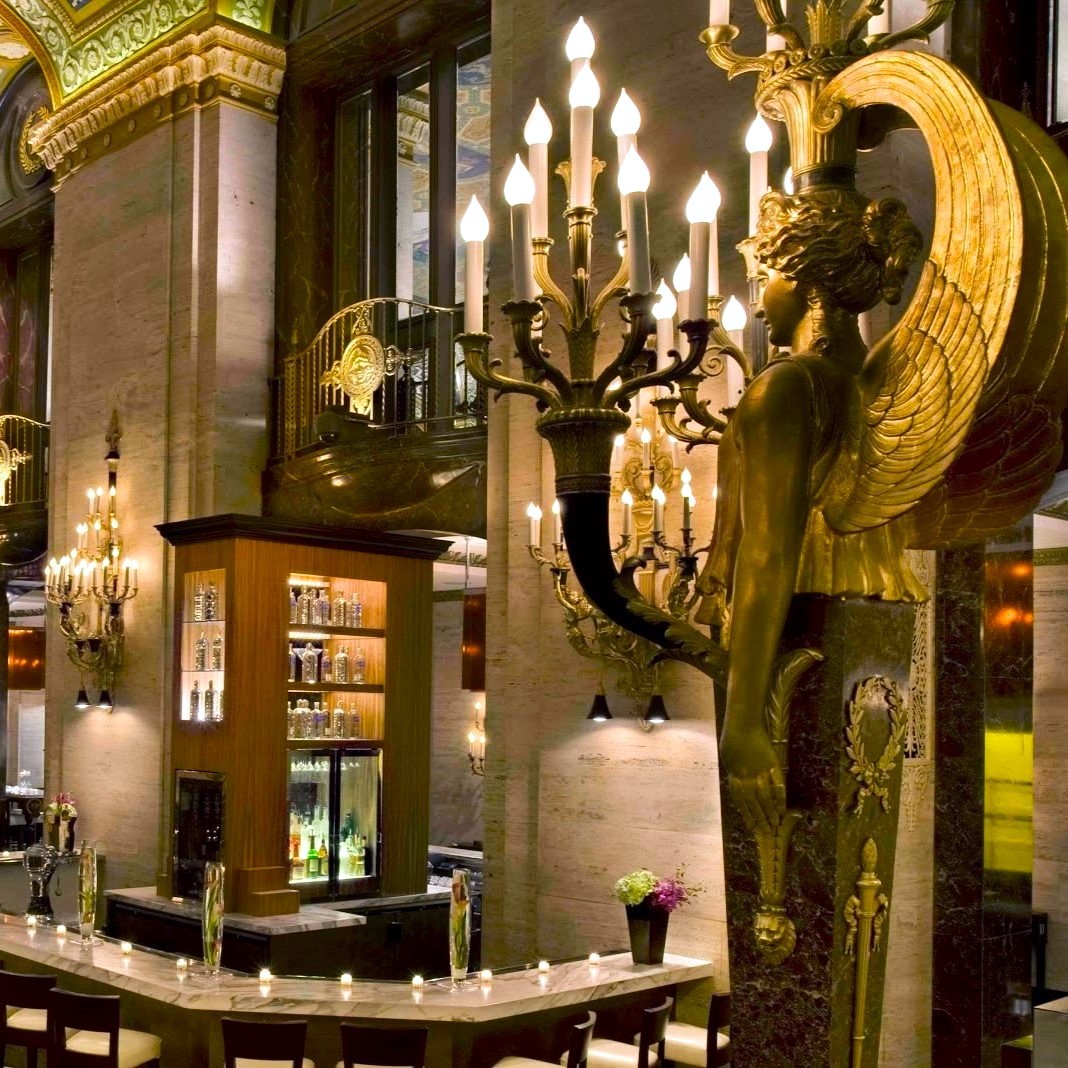 a large room with a large statue of a woman with wings and a bar
