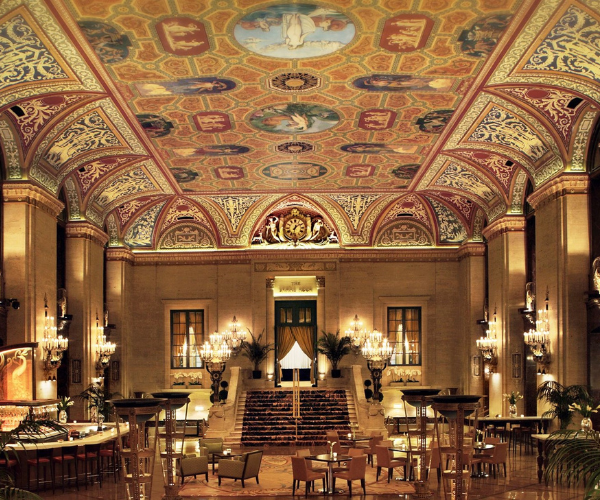 a large ornate room with tables and chairs with The Palmer House Hilton in the background