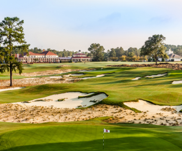 a golf course with a building and a flag