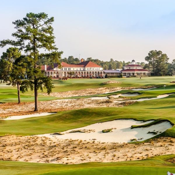 a golf course with a building and sand bunkers