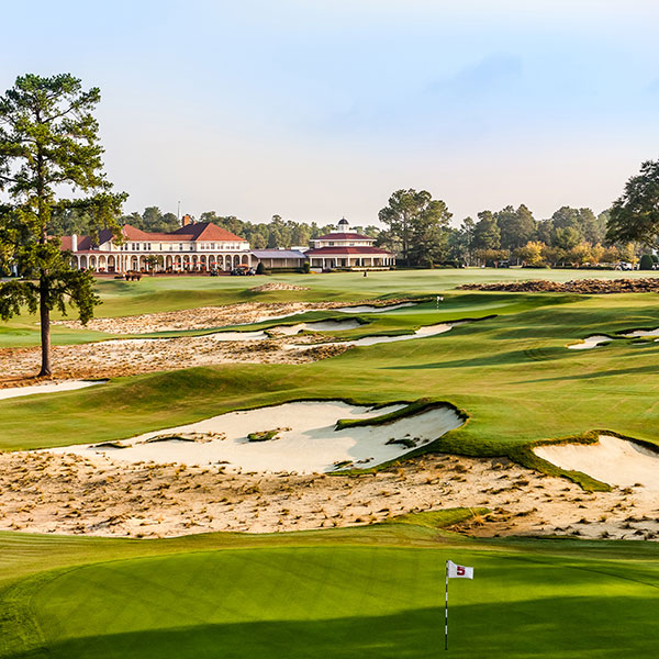 a golf course with a building and sand bunkers