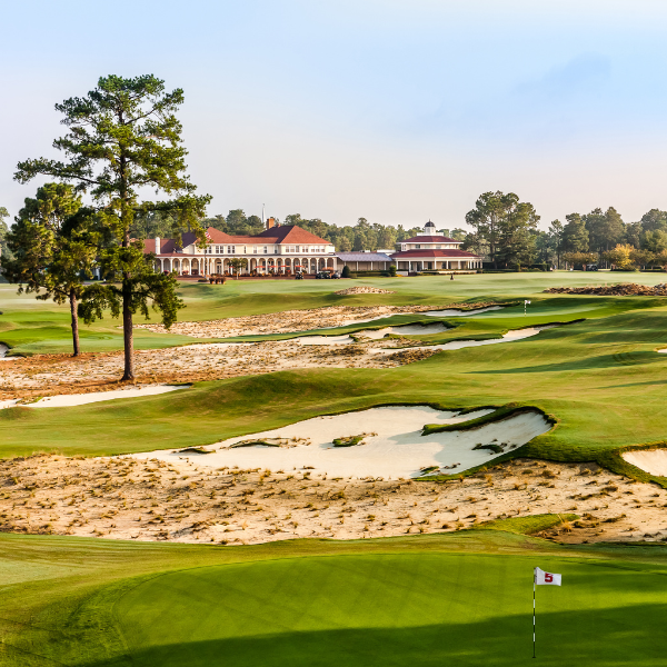 a golf course with a building and sand bunkers