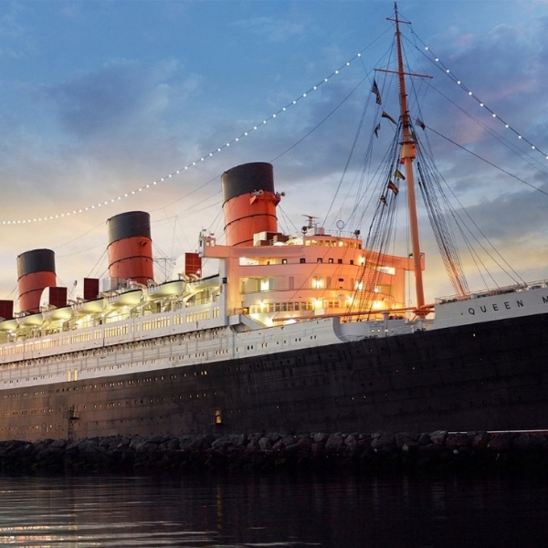 a large ship on the water with RMS Queen Mary in the background