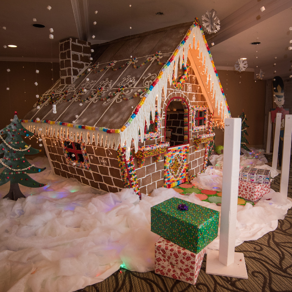 a gingerbread house with presents and a tree