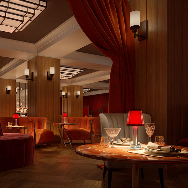 a room with a red couch and a table with glasses and a red lamp