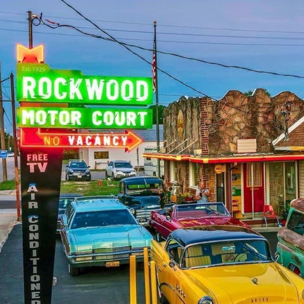 a sign with cars parked in front of a building