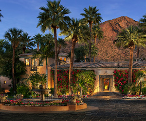 a building with palm trees and a fountain