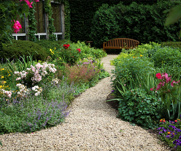 a garden with a bench and flowers