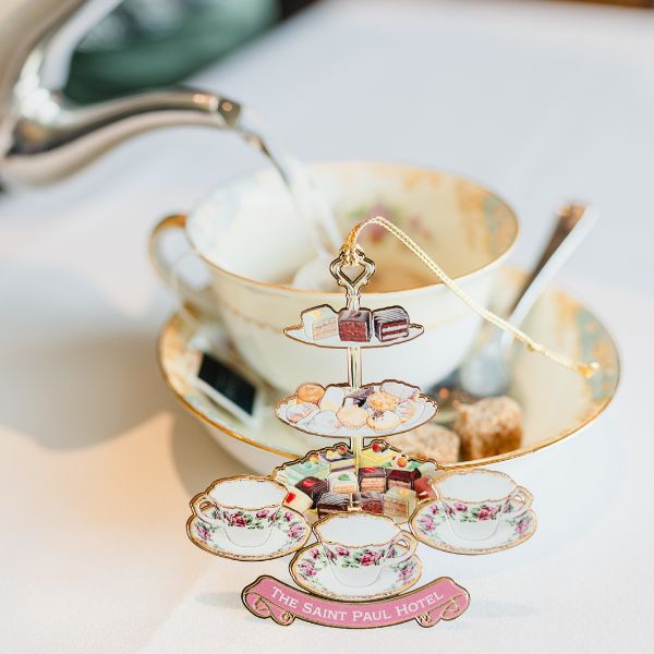 a teacup and teacup with a teapot pouring water into it