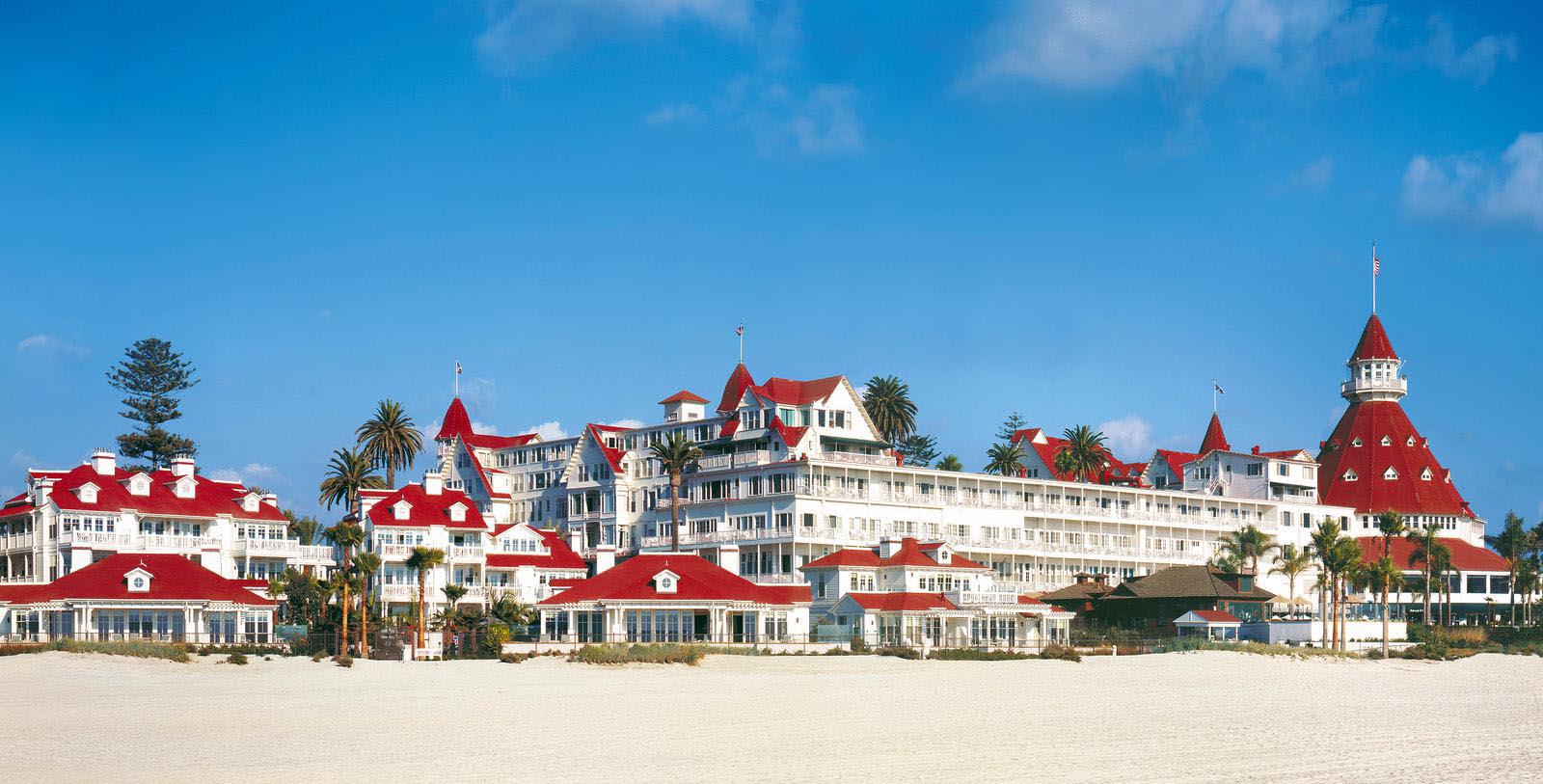 a large white building with red roofs with Hotel del Coronado in the background 27